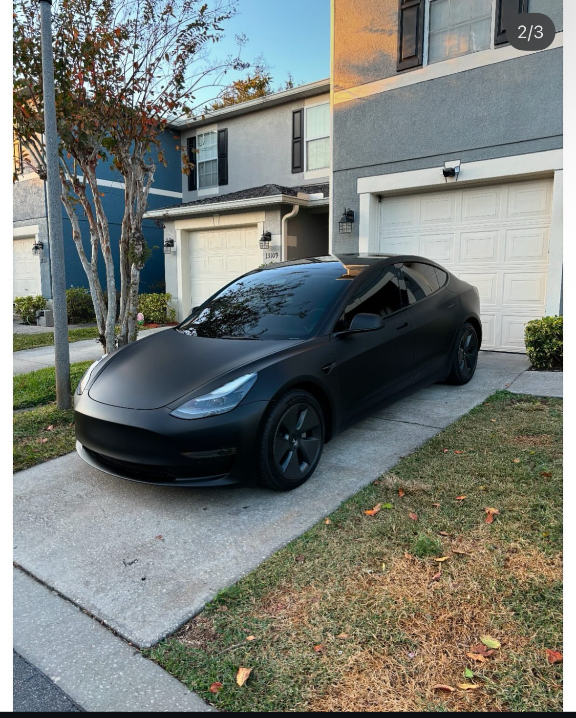 Matte black Tesla Model 3 with ceramic window tint — front three-quarter view in a Central Florida driveway